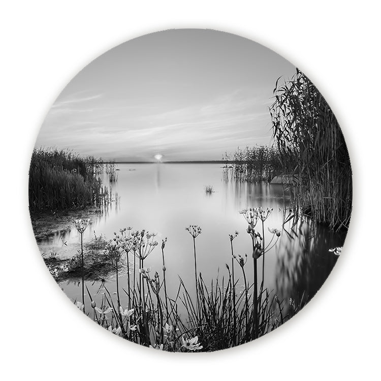 Zwart-wit muurcirkel met een rustig meer, riet en zonsondergang