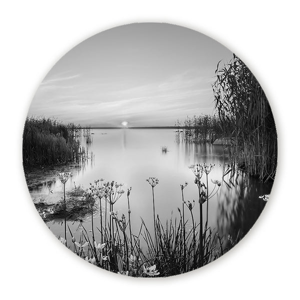Zwart-wit muurcirkel met een rustig meer, riet en zonsondergang