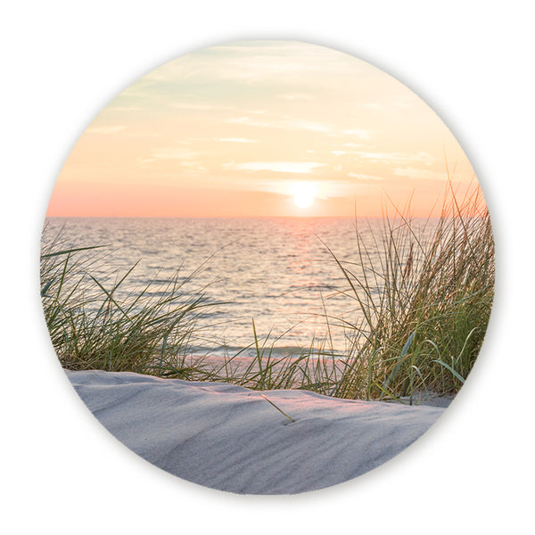 Muurcirkel met zonsondergang aan zee en duingras