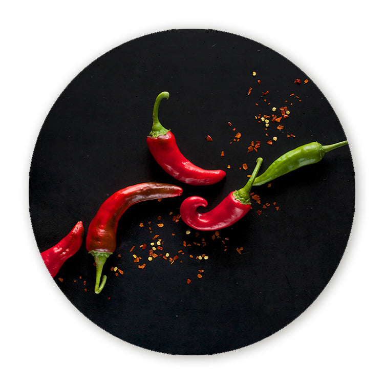 Muurcirkel met rode en groene chilipepers op een zwarte achtergrond
