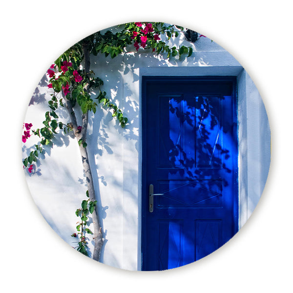 Muurcirkel met witte gevel, blauwe deur en roze bougainvillea